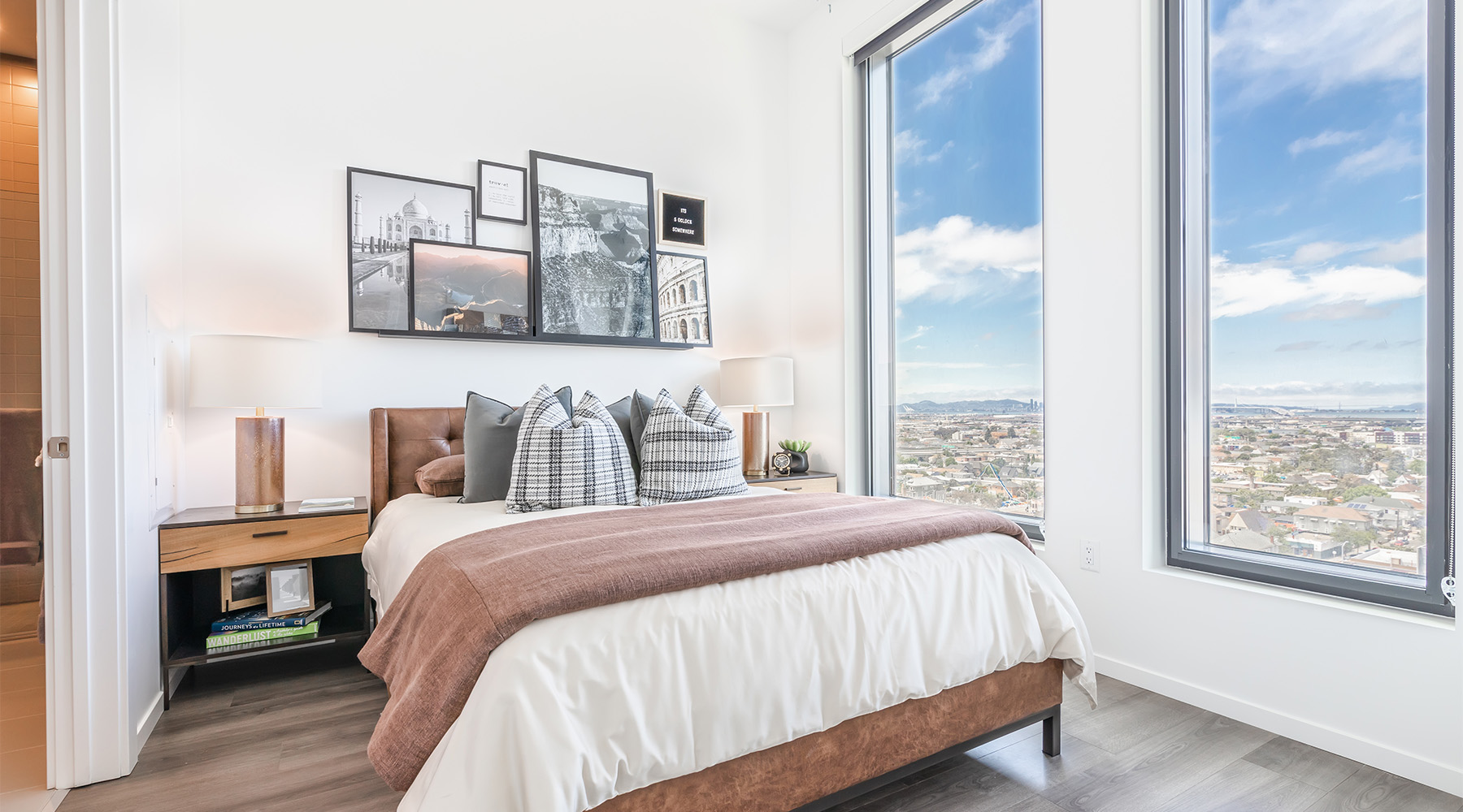 a bedroom with a bed and large windows