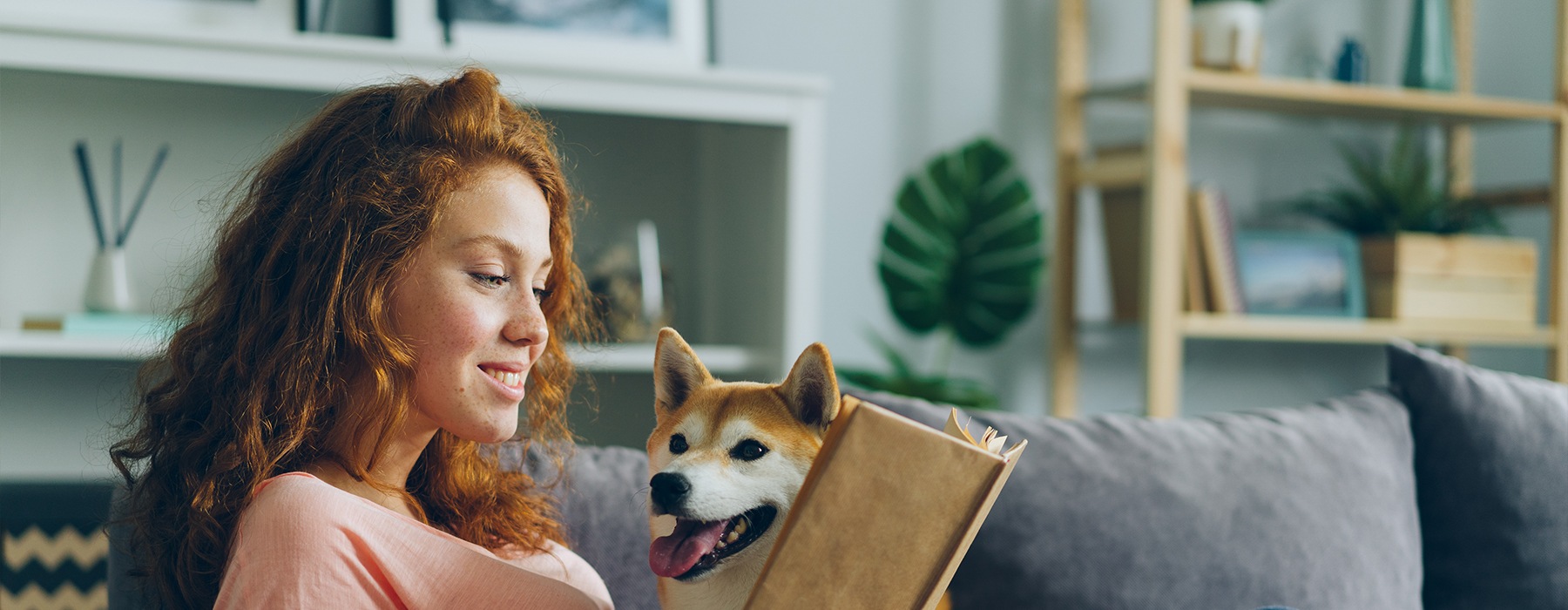a woman reading a book with a dog